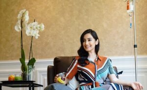 woman drinking juice while taking a drip